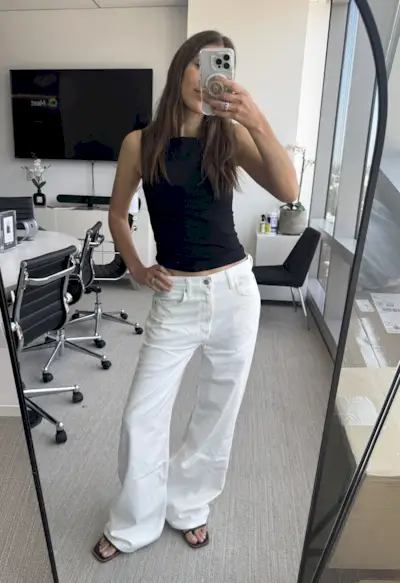 Woman in white baggy jeans and black top