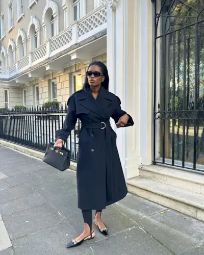 Fashion influencer @nlmarilyn wearing a chic winter outfit with black stirrup leggings.