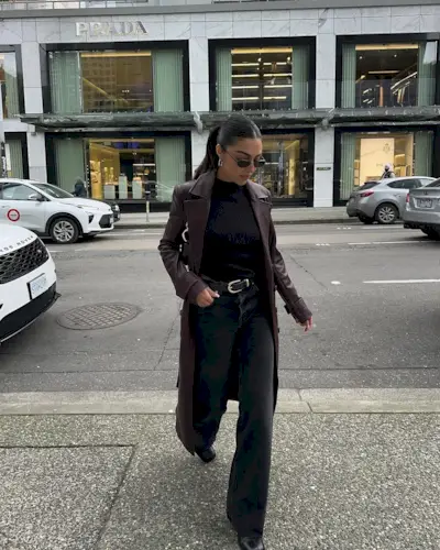 woman wearing long leather jacket and light black jeans