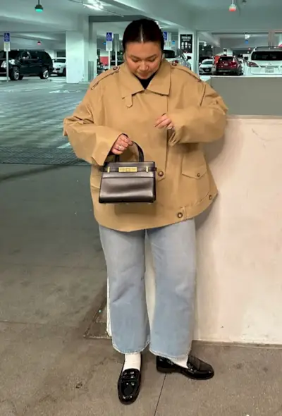 @marina_torres wears cropped flare jeans with a cropped trench coat and loafers