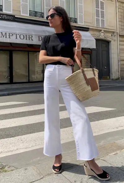 @leasy_inparis wears white cropped flare jeans with a black t-shirt, basket bag and espadrilles
