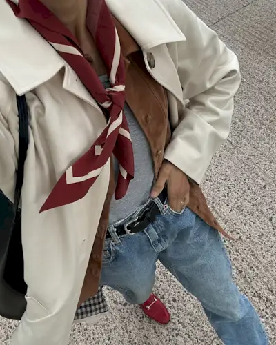 @_santinaharrison wears a red neck tie and loaders with a trench coat and blue jeans