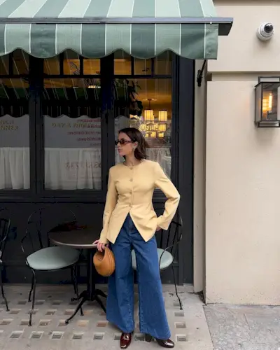 @tia_dewitt wears a yellow collarless blazer with blue jeans