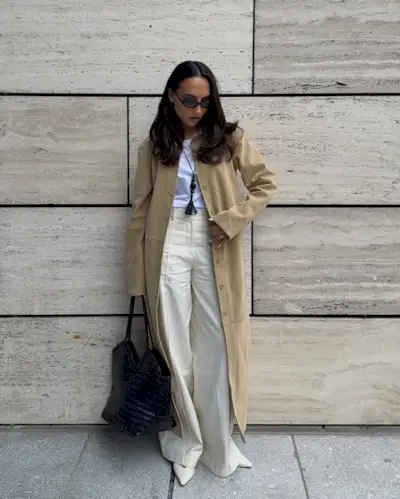 @ingridedvinsen wears a beige suede coat with cream wide-leg trousers and a brown bag