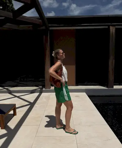 woman wearing white top and green shorts and flip flops