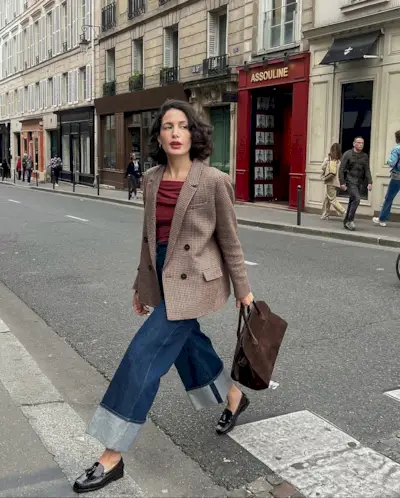 Influencer @melodiebanfield walks across the street in Paris wearing a red blazer, red top, cropped jeans and glossy leather loafers.