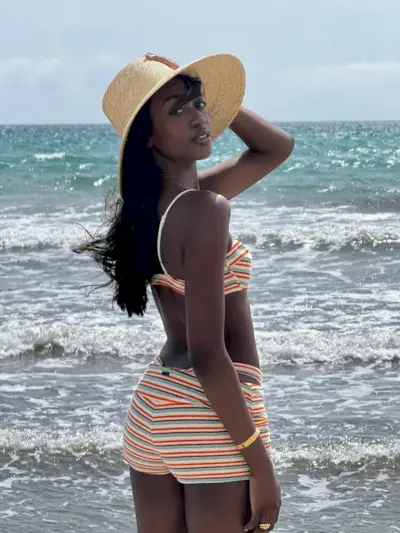 A woman standing wearing a Triangl boy short bikini set.