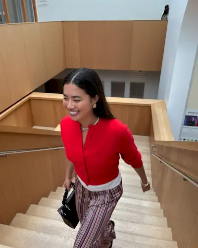 Influencer wears a red cardigan.
