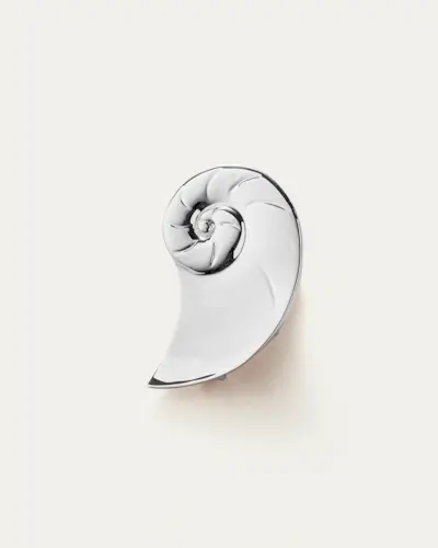 Shell jewelry trend on a woman wearing a green silk scarf over box braids with large shell hoop earrings and a matching green slip dress.