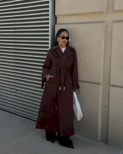 Influencer wears a burgundy trench coat.