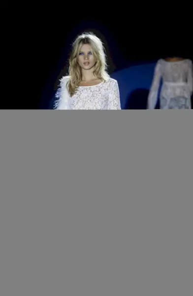 Kate Moss models a see-through, white lace minidress over white boy shorts from Gucci's Spring/Summer 1996 collection by Tom Ford (Photo by Davide Maestri/WWD/Penske Media via Getty Images)