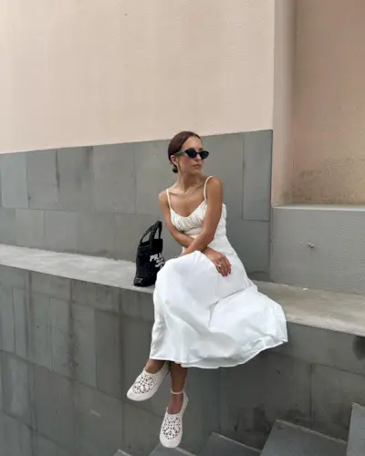 Influencer wears white shoes with a white dress.