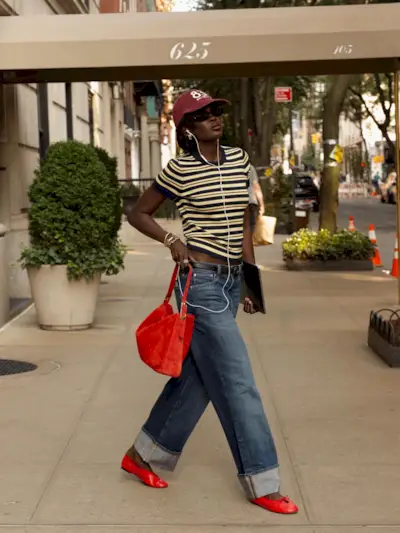 Influencer wearing a striped tee, jeans, and red ballet flats