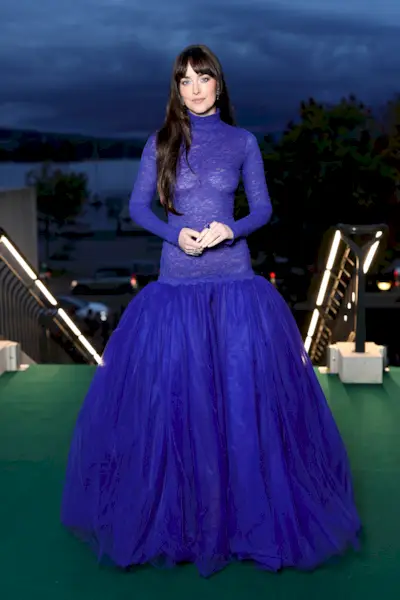 Dakota Johnson wears a bright blue gown on the red carpet in Zurich, featuring a drop waist silhouette and a sheer lace bodice