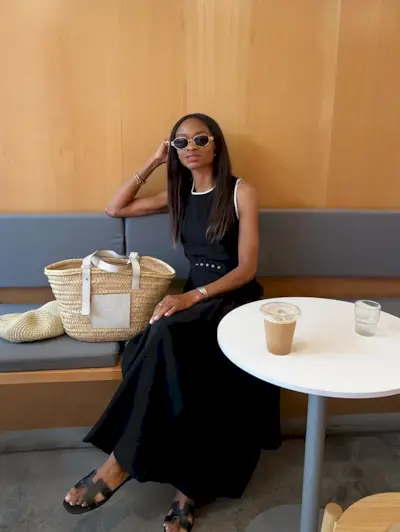 @symphonyofsilk wears a black dress with a full skirt and carries a basket bag