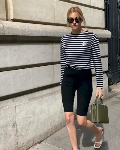 Camille wears white mules, black pedal pushers, stripe long-sleeve shirt.