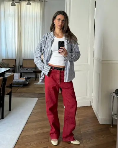 Anne wearing red pants, white flats, a white tank, black belt, and stripped button-down.