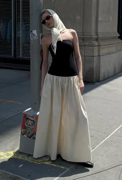 A woman's white dress outfit with a two-tone black and white strapless dress styled with black ballet flats and a white scarf.