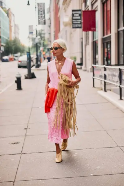 Woman wearing a red accent sweater during NYFW S/S 26.