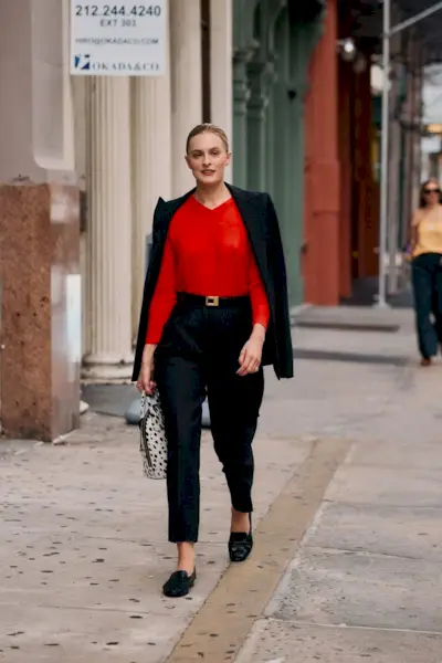 Woman wearing a red accent sweater during NYFW S/S 26.