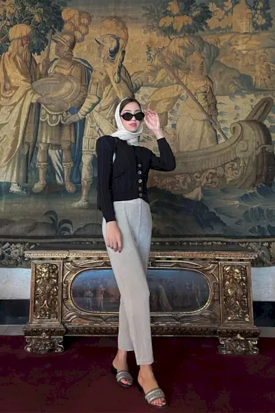 Woman wearing a black cardigan and flowy pants.