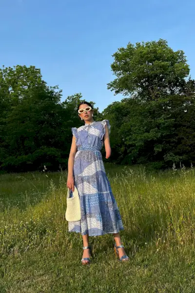 Woman standing in a field wearing a cottagecore outfit.