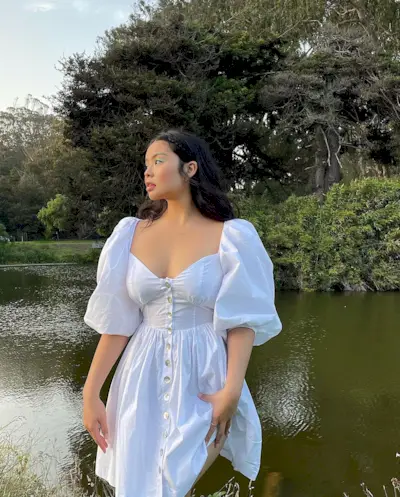 Woman wearing a white dress with puff sleeves.